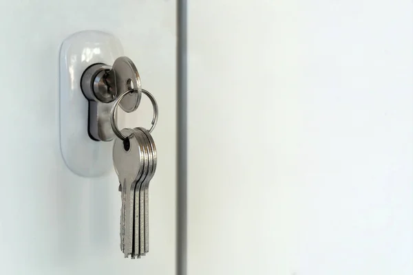 Mortise lock in a plastic door. A bunch of new keys. Opening or closing a room or the Concept of forgetfulness and distraction of the landlord or receiving new housing. Copy Empty space for text. — Stock Photo, Image