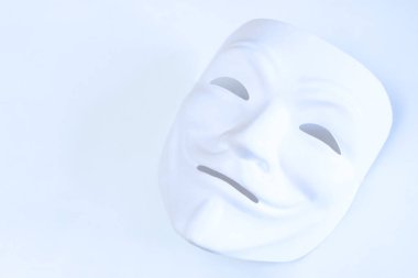 Beyaz arka planda beyaz maske. İsimsiz bir hacker'ın sembolü. Kopya alanı. Hafif bir şekilde çekim. Film tanesinin etkisi.