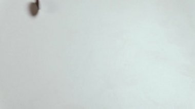 Bir dime sikke döner ve çerçevenin ortasında durur. Amerikan küçük nakit beyaz bir masada hareket.