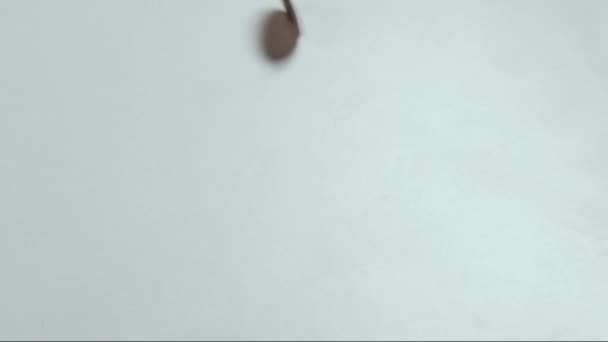 Petite unité américaine de métal d'argent se déplace sur une table blanche. Une vieille pièce de un cent tourne et s'arrête au centre du cadre .