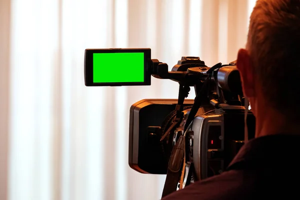 Green LCD display on high definition television camera. Videographer at work removes the story for the news. Template template for the design of information about the TV.