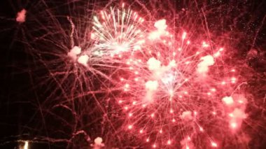 Siyah bir arka plan üzerinde yakın çekim kırmızı ve altın şenlikli havai fişek. Yeni yıl, noel, şehir günü veya bağımsızlık günü kutlamaları için bir selam ile karanlık gökyüzünün soyut arka plan