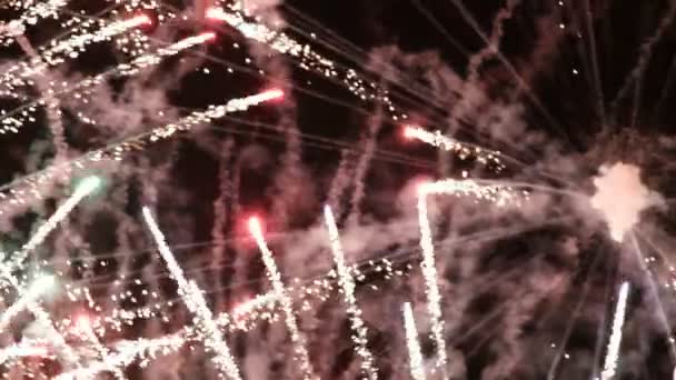 Super close-up de fumaça e flashes ardentes de um fogo de artifício festivo em um fundo preto. Contexto abstrato do céu escuro com uma saudação do ano novo, Natal, dia da cidade ou dia da independência . — Vídeo de Stock