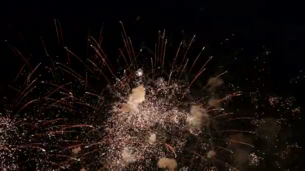 Прекрасный праздничный фейерверк в ночном небе. Атрибут празднования юбилея города, независимости, Нового года, Рождества. Крупный план дыма и огненных вспышек салюта на черном . — стоковое видео