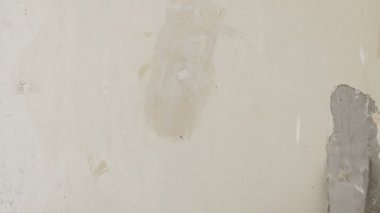 Onarım ve inşaat. Spatula ile mavi eldiven bir el eski sıva duvar temizler.