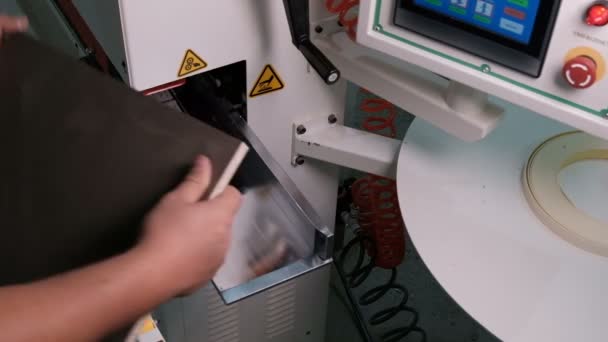 Una máquina moderna con un panel de control y un monitor para afilar piezas de aglomerado. Primer plano de las manos masculinas. El borde blanco está pegado al blanco marrón. Ruido industrial de sonido real en la producción de muebles . — Vídeo de stock