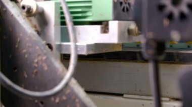 Kenarları yonga levha parçalarına yapıştırmak için makine. Mobilya imalatı. Sığ alan derinliği, seçici odak. Makinedeki silindirlerin otomatik hareket mekanizması.