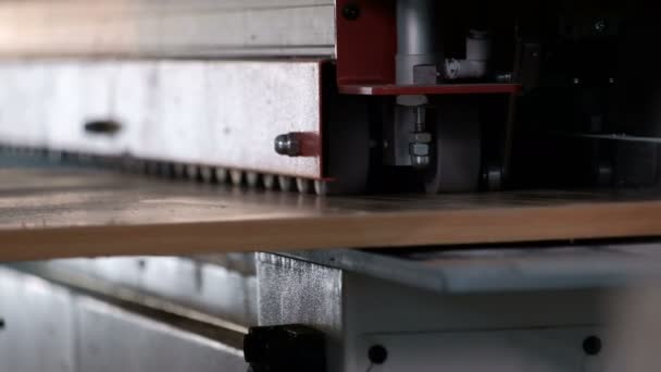 Machine voor het lijmen van randen op spaanplaat onderdelen. Meubel fabricage. Ondiepe scherptediepte, selectieve focus. Het mechanisme van automatische beweging van de rollen op de machine. — Stockvideo