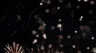 Gece gökyüzünde harika bir selam. Renkli selamların göz kamaştırıcı parıltıları. Bağımsızlık Günü, Yeni Yıl, Noel ve Zafer Günü.