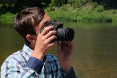 Kamera bir gencin ellerinde eridi. Ekose gömlekli bir adam DSR 'ın gözetleme deliğinden bakıyor. Garip bir durum. Yanmış bir cihazla fotoğraf çekmek. Isı ya da ateşin etkileri.