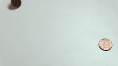 Amerikan sikkeleri beyaz bir masada döner. Yazı mı tura mı? Tercih ve emtia-para ilişkilerinin sembolü. Zenginlik ya da yoksulluk.