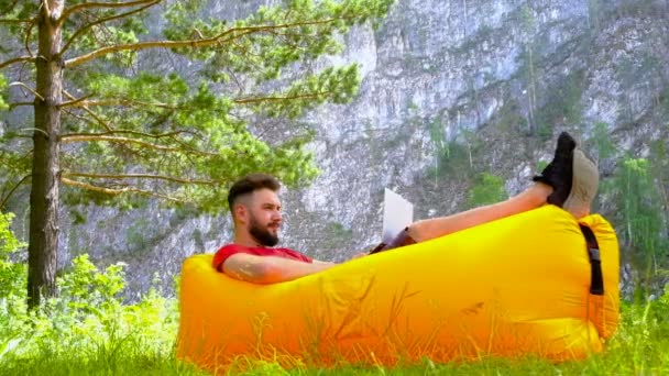 Giovane Ragazzo Brutale Con Barba Trova Divano Gonfiabile Lavora Computer — Video Stock