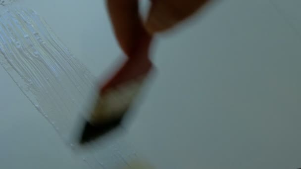 Appliquez de la colle ou de la peinture sur une surface blanche avec un pinceau. Réparation, travaux à domicile ou production industrielle 