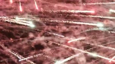 Yakın plan. Yılbaşı, Noel, Bağımsızlık Günü ve diğer etkinliklerin tasarımları için şenlikli bir arka plan. Göz kamaştırıcı havai fişekler gökyüzüne yayılıyor.