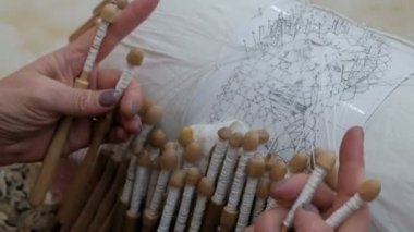 Hanımların elleri, bobbin danteli, bobinleri dokuma. Eski moda dantel ören bir kadın. El işi. Yakın plan..