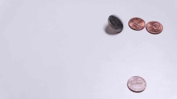 Αμερικάνικα νομίσματα στριφογυρίζουν σε λευκό τραπέζι. Ένα σεντ, ένα τέταρτο του δολαρίου. Αντιγραφή χώρου. Κορώνα ή γράμματα. Τα χέρια μαζεύουν λεφτά. Πλούτος ή φτώχεια. — Αρχείο Βίντεο
