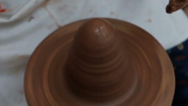 ろくろが回転している。茶色の粘土製品を形成する女性の手のクローズアップ. — ストック動画