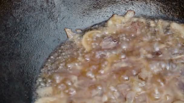 Carne cortada com cebolas em óleo fervente em um caldeirão. Espaço para cópia. Cozinhar pilaf oriental tradicional. Close-up . — Vídeo de Stock