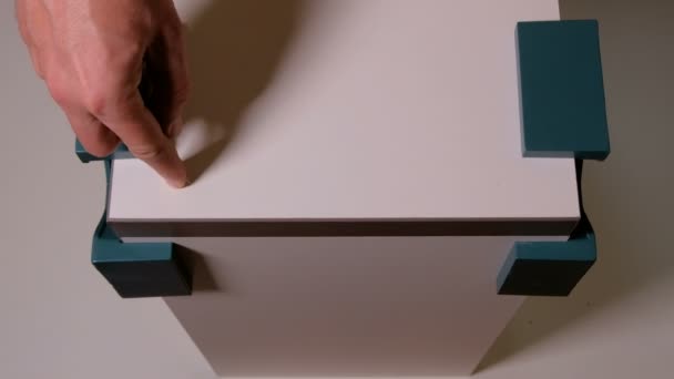 一只雄性手在白板上用锥子刺穿一个洞 家具配件用夹角紧固成直角 从上面看 — 图库视频影像