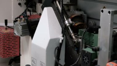 Kenarları yonga parçalarına yapıştırma makinesi. İçeriden. Marangozluk atölyesinde mobilya parçalarının kenarı. Endüstriyel üretim ve zanaat. Sesli video.