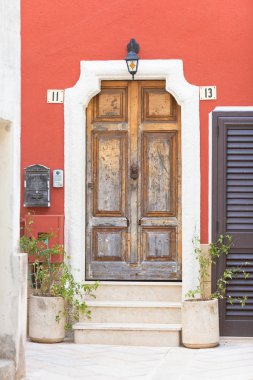 Presicce, Apulia, İtalya - eski bir ahşap kapı ve bir bordeaux cephe