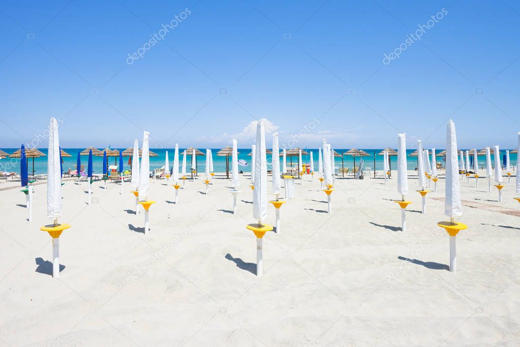 Alimini Grande, Apulia, Italy - Folded sunshades at the beautiful beach of Alimini Grande
