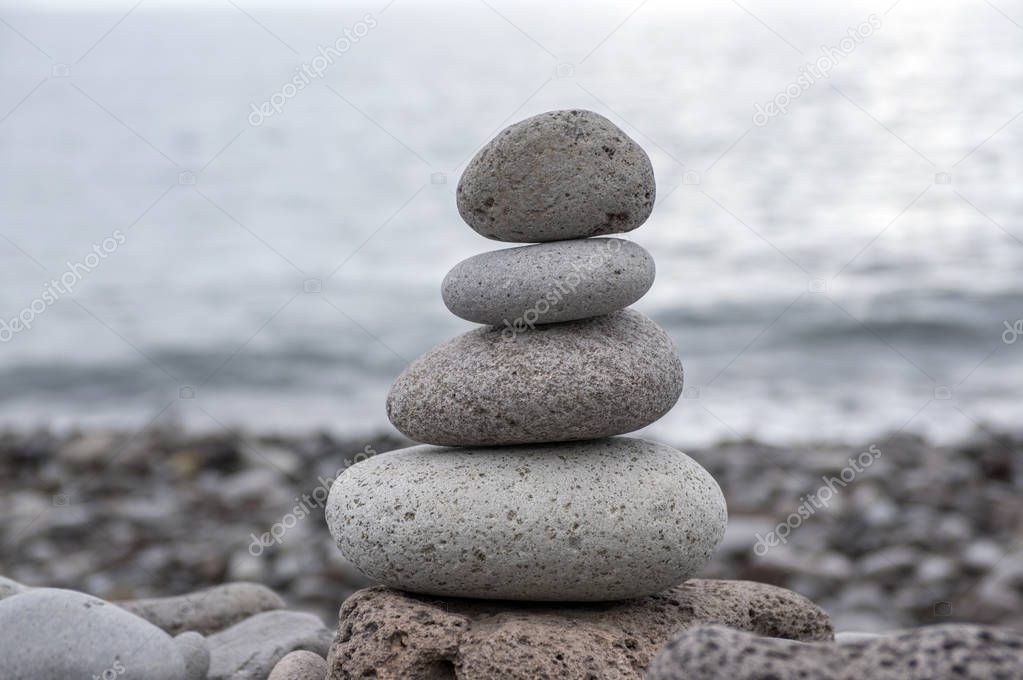 Stone cairn tower, poise stones, rock zen sculpture, light grey pebbles