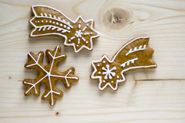 Düzenlenmiş boyalı geleneksel Noel gingerbreads gün ışığında, ahşap tepsi üzerinde ortak lezzetli tatlılar için tatil, çeşitli şekiller - kar tanesi ve kuyrukluyıldızlar var.