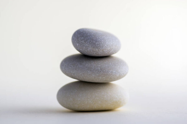 Harmony and balance stack of smooth white pebbles on light background, stone tower