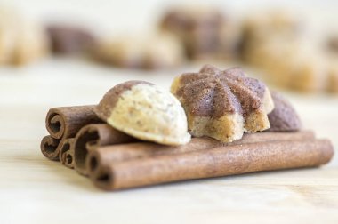 Tarçın sandbakelse Noel kurabiyeleri, iki renkli, koyu kahverengi kakao ve vanilya altın kahverengi, tarçın ham kabuk baharat, yıldız ve fındık şekiller üzerinde ahşap arka plan ışık