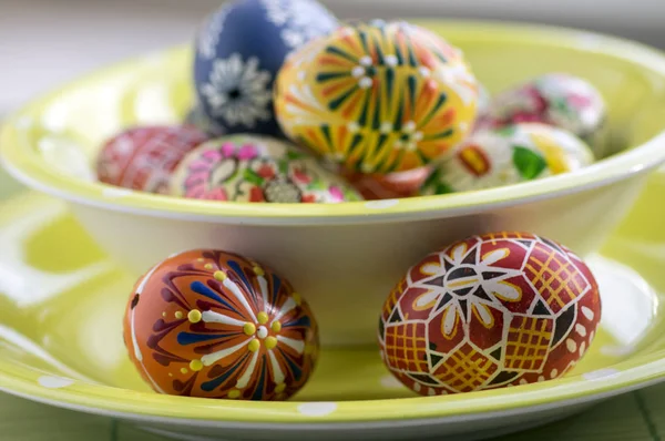 一组蜡画复活节彩蛋在绿色斑点碗桌上 蜡饰品 彩绘花卉 彩虹色 — 图库照片