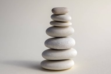 Uyum ve denge, cairns, basit duruş taşlar beyaz arka plan, rock zen heykel, beyaz çakıl, tek kule, sadelik