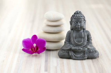 Uyum ve denge, basit çakıl Kulesi ve hafif ahşap yüzeyi koyu gri Buda heykelciği