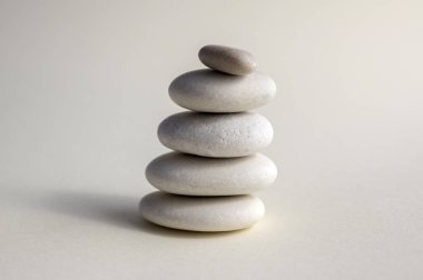 Uyum ve denge, cairns, basit duruş taşlar beyaz arka plan, rock zen heykel, beyaz çakıl, tek kule, sadelik
