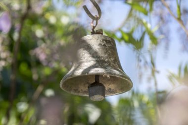 Küçük metalik oryantal çan Bahçe, güneşli gün, yeşil etrafında asılı