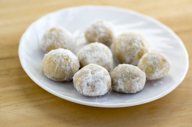 Beyaz Noel kurabiyeleri, lezzetli topları içine fındık ve pudra şekeri ile plaka ve ahşap masa