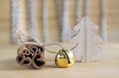 Taze çiğ tarçın tahta masada kırmızı yay, jingle bell, arka plan, Noel ağacı ve Noel zincirleri üzerine düşünceler ile bağlı
