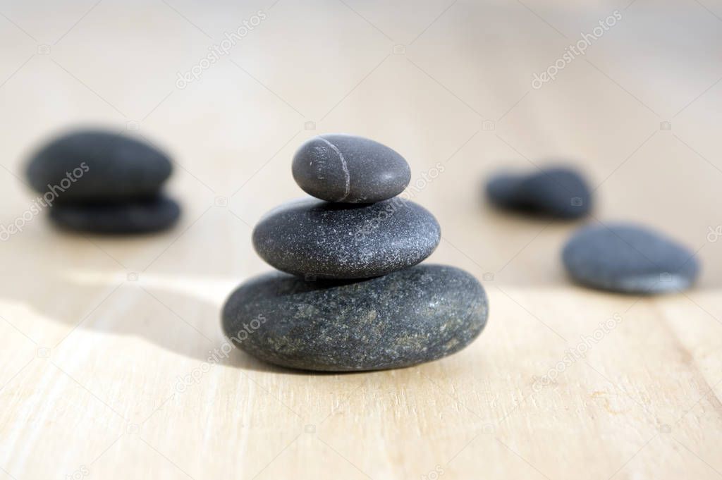 Harmony and balance, poise stones on wooden table, black pebbles in sunlight