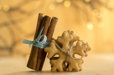 Jüt halat, mavi yay, Noel kar taneleri ve baharat ahşap masa üzerinde taze tarçın ile geleneksel lezzetli çek gingerbreads bağlı