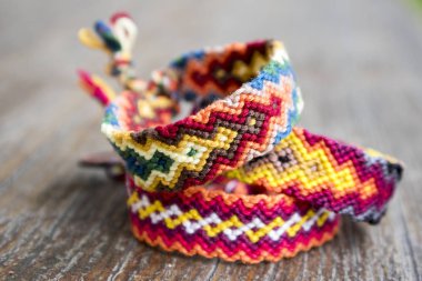 Üç basit el yapımı ev yapımı doğal dokuma dostluk bilezik ahşap arka plan, gökkuşağı renkleri, Damalı deseni