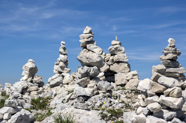 View point with white stone cairns on hiking trail Alta Via del Monte Baldo, ridge way in Garda Mountains, mountain edge
