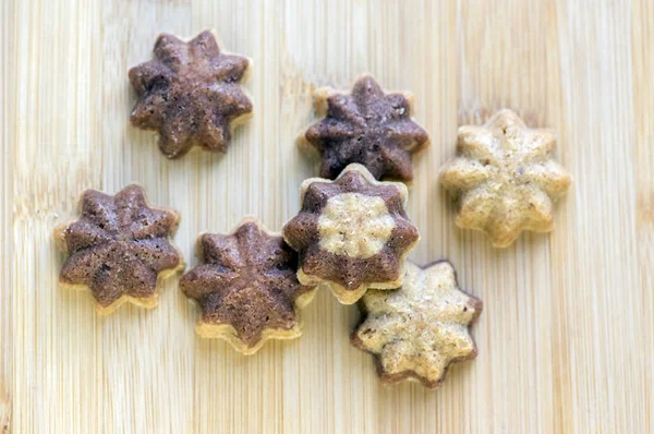 Cinnamon sandbakelse christmas cookies, two color, cocoa dark brown and vanilla light golden brown, delicious czech cuisine cookies, stars shapes on wooden background