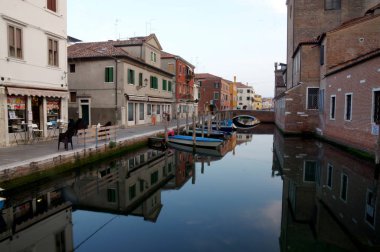 15 Haziran 2017 Chioggia sokakları, kanal, tekneler, eski tarihi binaları ve yansımaları ile romantik bir sahne erken akşam