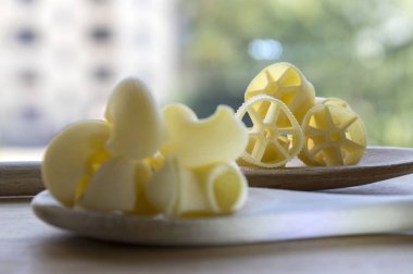 Çeşitli ahşap masa, yeşil arka plan açık havada üzerinde iki tahta kaşık makarna karışımı