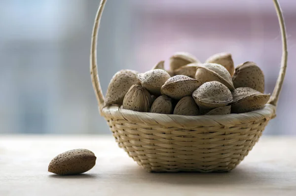 Almonds in hard shells, pile in small wicker basket