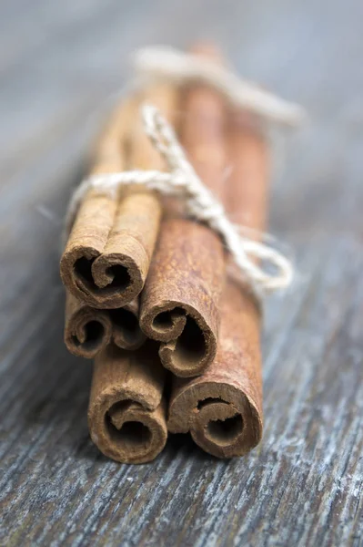 Fresh raw cinnamon sticks on wooden table tied with jute natural twine