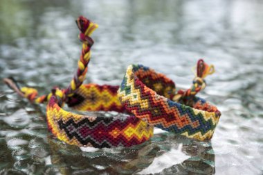 İki basit el yapımı ev yapımı doğal dokuma dostluk bilezik cam masa, gökkuşağı renkleri, Damalı deseni