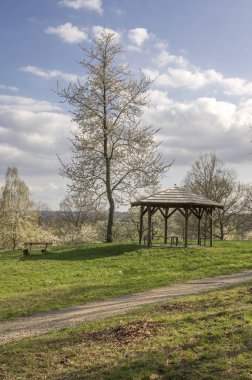 Çiçeklenme kiraz ağacı ve ve ahşap çardak house, mavi gökyüzü beyaz bulutlar ile