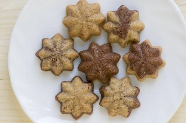 Cinnamon sandbakelse christmas cookies, two color, cocoa dark brown and vanilla light golden brown, delicious czech cuisine cookies, star shapes on white plate