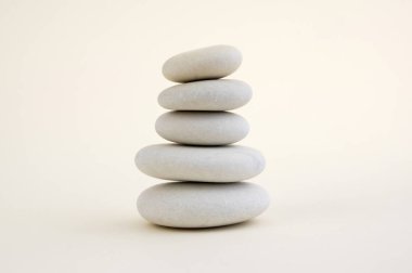 Uyum ve denge, cairns, basit duruş taşlar beyaz arka plan, rock zen heykel, beş beyaz çakıl, tek kule, sadelik